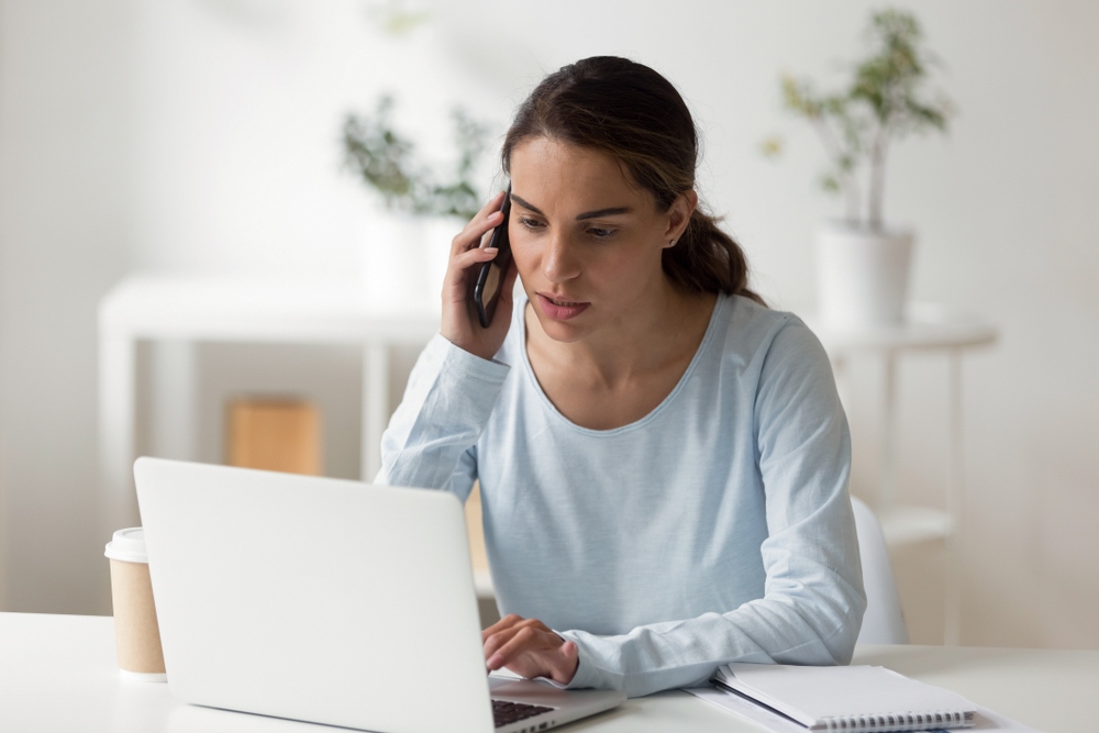 Serious,Businesswoman,Talking,By,Phone,,Work,At,Laptop.,Office,Secretary